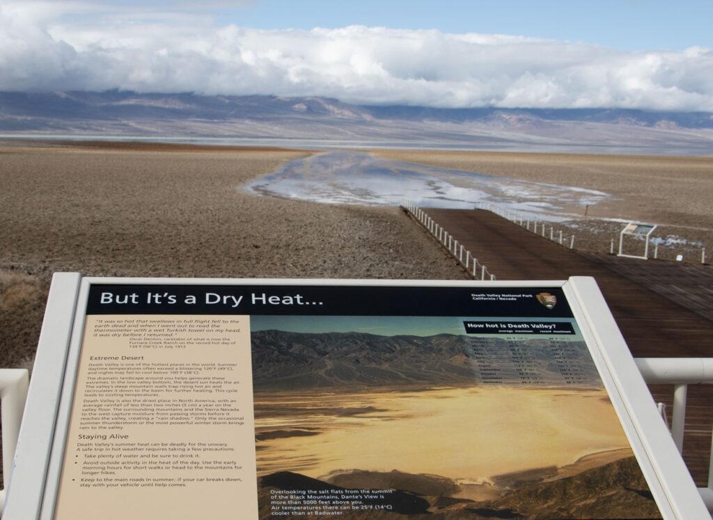 A sign at Badwater Basin describes Death Valley as a hot, dry place. In the background, recent rains have increased the size of the temporary lake, an arm of which now covers the trail.
NPS/Giovanna Ponce