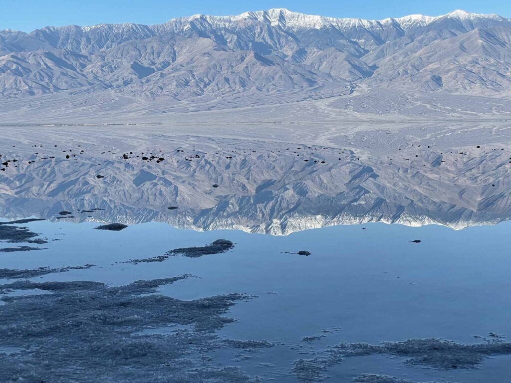 Telescope Peak, reflected in the temporary shallow lake at Badwater Basin in late December. NPS