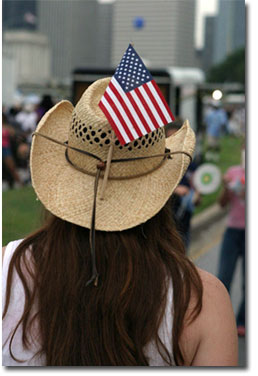 An onlooker at Fourth of July in Houston finds the perfect place for her flag.