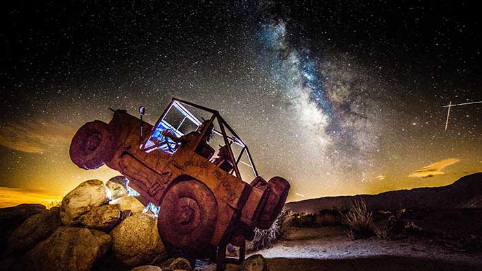 A departure from the monster theme, a jeep high-centers on a rock pile while following the Milky Way for navigation.